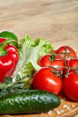 Close-up still life of assorted fresh vegetables and herbs on vintage wooden background, top view, selective focus.