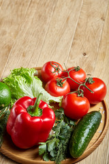 Close-up still life of assorted fresh vegetables and herbs on vintage wooden background, top view, selective focus.