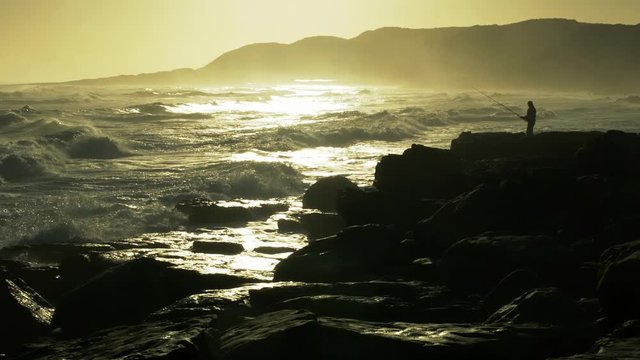 Fisherman sets up fihing pole on ocean coast