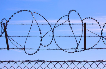 Barbed wire fence provide security - blue sky background with copy space