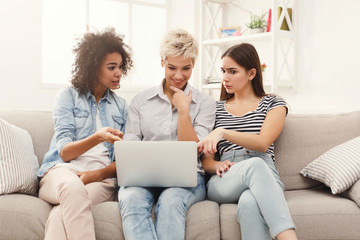 Three beautiful women using laptop at home