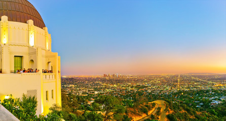 Obraz premium Widok na Obserwatorium Griffitha i centrum Los Angeles o zachodzie słońca.