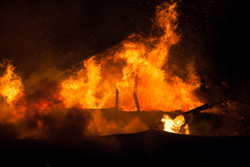 Burning fire flame on wooden house roof