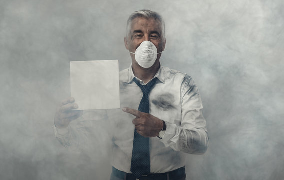 Man with pollution mask holding a sign