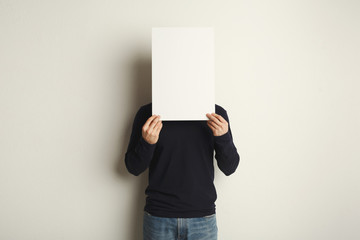 Young man closed face with blank white paper