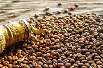A coffee cup with coffee beans on an old wooden table. Fried coffee beans on a wooden background. Viewing from above.