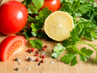 Fresh vegetables Tomatoes Lemon Parsley Pepper coarse Salt on a cutting Board