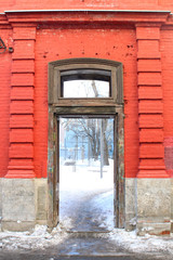 Old red wall with wooden door