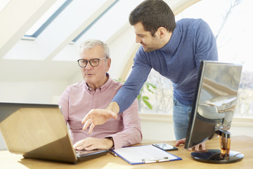 Brainstorming at the office. Young financial assistant businessman working  with elderly financial businessman and consulting about business. Teamwork. 