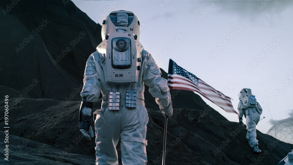 Wall mural shot of the two astronauts exploring mars/ red planet. one cosmonaut carries american flag. technolo