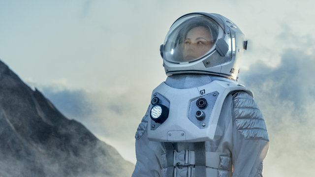 Shot of Female Astronaut in the Space Suit Looking Around Frozen Alien Planet. Advanced Technologies, Space Travel, Colonization Concept.