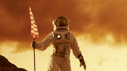 Astronaut Wearing Space Suit Plants American Flag on the Red Planet/ Mars, Looks Towards the Horizon. Patriotic and Proud Moment for the Whole of Humanity. Space Travel and Colonization Concept.