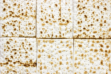 An overhead photo of many pieces of matzah or matza. Matzah for the Jewish Passover holidays. Place for text, copy space. Selective soft focus.