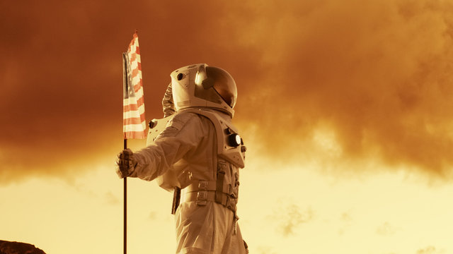 Astronaut Wearing Space Suit Plants American Flag on the Red Planet/ Mars. Patriotic and Proud Moment for the Whole of Humanity. Space Travel and Colonization Concept.