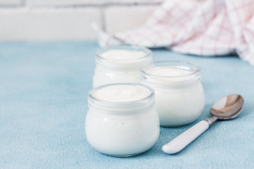 Instant pot homemade yogurt in glass jars on light blue background. Selective focus, copy space.
