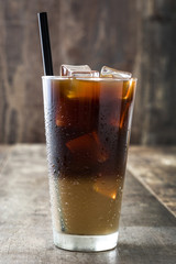 Iced coffee in glass on wooden table. 