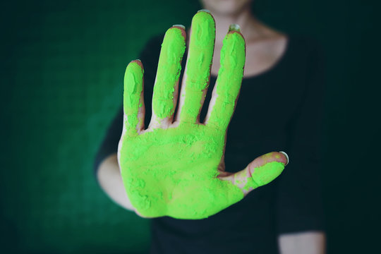 Mano de una mujer manchada con polvo verde