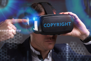 Business, Technology, Internet and network concept. Young businessman working in virtual reality glasses sees the inscription: Copyright
