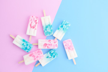 Homemade Ice cream sticks , popsicle , ice pop or freezer pop on blue and pink pastel colors...