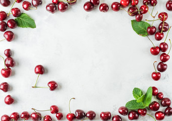 Top view at frame of ripe fresh red crab cherries with mint leaves. Frame with free space for text