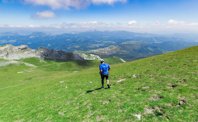Fototapeta premium A mountaineer climbing down from Gorbea Mountain on a sunny day, Spain