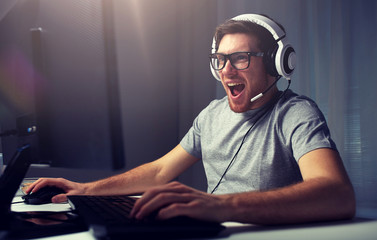 man in headset playing computer video game at home - obrazy, fototapety, plakaty