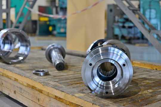 After the machining on the machine, new parts from the gearbox lie on a wooden rack in the workshop.