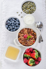 Healthy breakfast with granola, berries and youghurt on white