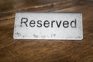 reserved sign isolated on wooden background   in restaurant