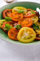 Colorful heirloom tomatoes salad on white