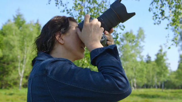 Professional nature photographer, taking pictures, using a digital SLR camera - hand-held shot, ProRes