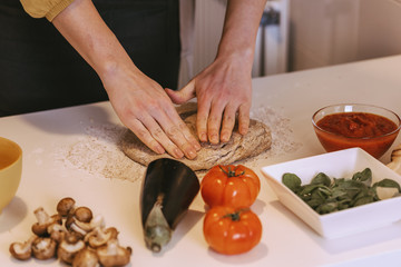 Woman preparing delicious pizza with healthy ingredients.