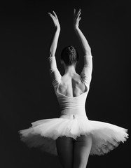Young beautiful ballerina is posing in studio