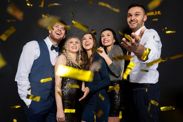 happy friends at party under confetti over black