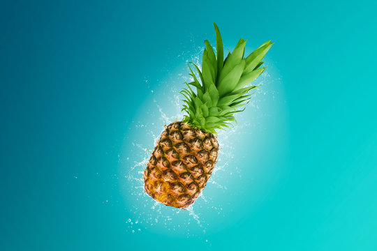 Water splashing out of a fresh pineapple isolated on blue background\