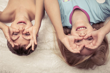 Lovely brother and sister lying in bed at home.