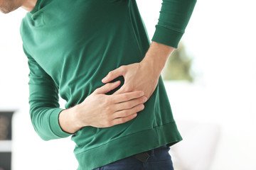 Young man suffering from pain in his side at home