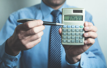 Businessman showing calculator.