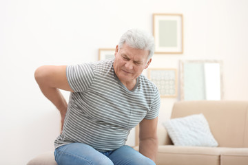 Mature man suffering from back pain at home