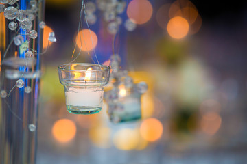 Candle light closeup with blurred background. Copy Space. New years eve celebration concept. Candles hanging from a center table with bokeh lights.