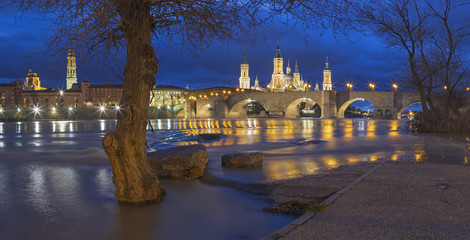 Zaragoza - The bridge Puente de Piedra and Basilica del Pilar with the riverside of Ebro river at...