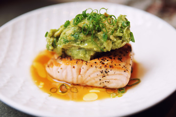 Grilled salmon fillet with guacamole and crushed nuts, toned
