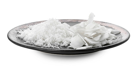 Plate with coconut flakes on white background