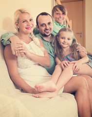 parents with two children posing in home interior