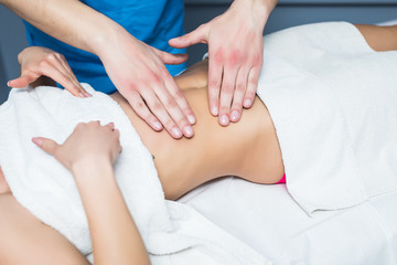 Obraz na płótnie Canvas Masseur conducts anti-cellulite massage of the woman abdomen