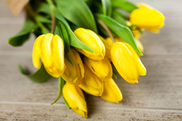 Obraz premium Yellow tulips on wooden background