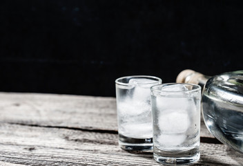 Cold vodka in shot glasses on a black background