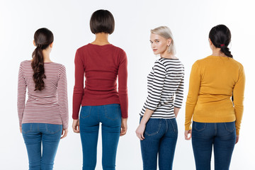 Obraz premium Feministic movement. Nice attractive blonde woman standing among her friends and turning to you while participating in the feministic movement