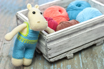 Knitted toy hippopotamus on a wooden background