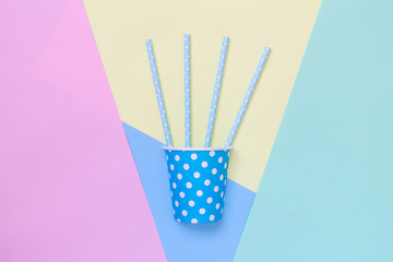 Top view of tropical drink with drinking straws against multicolored background.